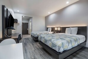 A modern hotel room with two beds, a desk, and a chair. - Studio 6 Katy, TX (Katy)