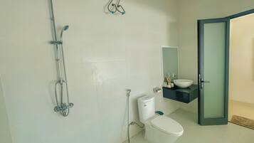A bathroom with a toilet, a sink, and a shower.