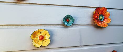 Un mur composé de planches de bois disposées horizontalement et agrémenté de boutons décoratifs en forme de fleurs, déclinés dans différentes couleurs.