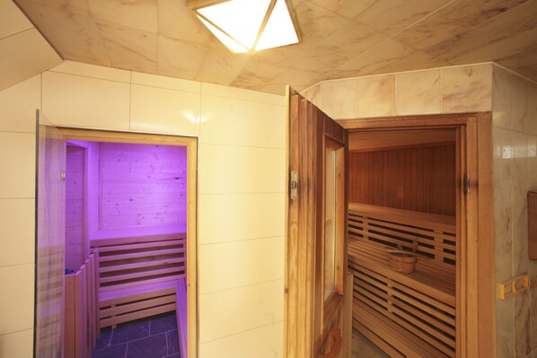 Un sauna con bancos de madera y pared de azulejos.
