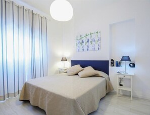 2 dormitorios y tabla de planchar con plancha