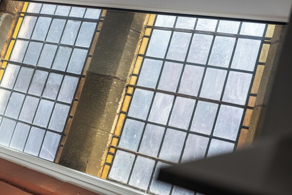 A window with a grid pattern and a yellow line on the sill. - Emmanuel Church Apartments (Warrington)
