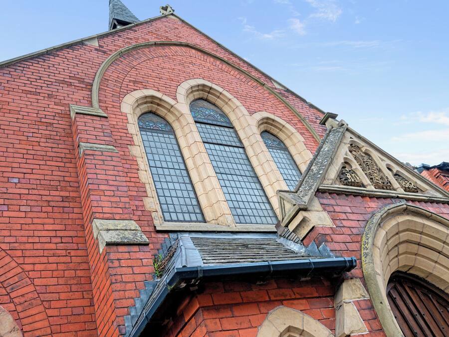 A red brick building with arched windows and a pointed roof.