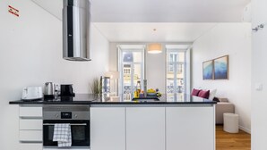 Una cocina moderna con armarios blancos, una campana extractora de acero inoxidable y una isla central.
