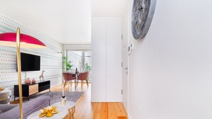A modern living room with a sofa, coffee table, and a dining area with chairs and a table. - CSA18 Premium Design Apartment (Lisbon)