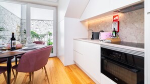 A modern kitchen with white cabinets, a built-in oven, and a countertop with a toaster. - CSA18 Premium Design Apartment (Lisbon)