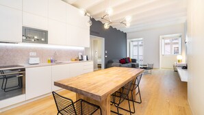 A modern kitchen with a wooden island, white cabinetry, and a built-in oven. - LS48 Prime Location Upscale Apartment (Lisbon)