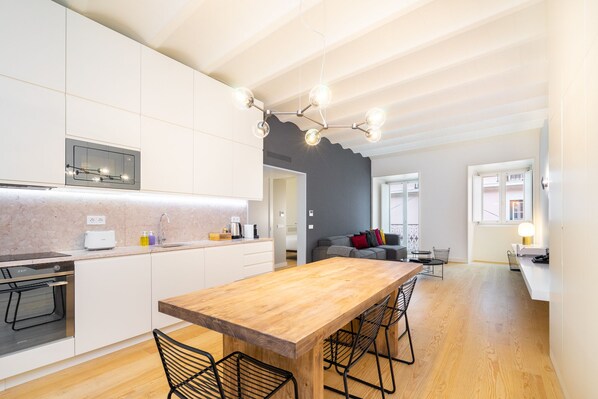 A modern kitchen with a wooden island, white cabinetry, and a built-in oven. - LS48 Prime Location Upscale Apartment (Lisbon)