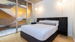 A modern bedroom with a large bed, a glass door leading to a spiral staircase, and a minimalist design. - LS48 Prime Location Upscale Apartment (Lisbon)