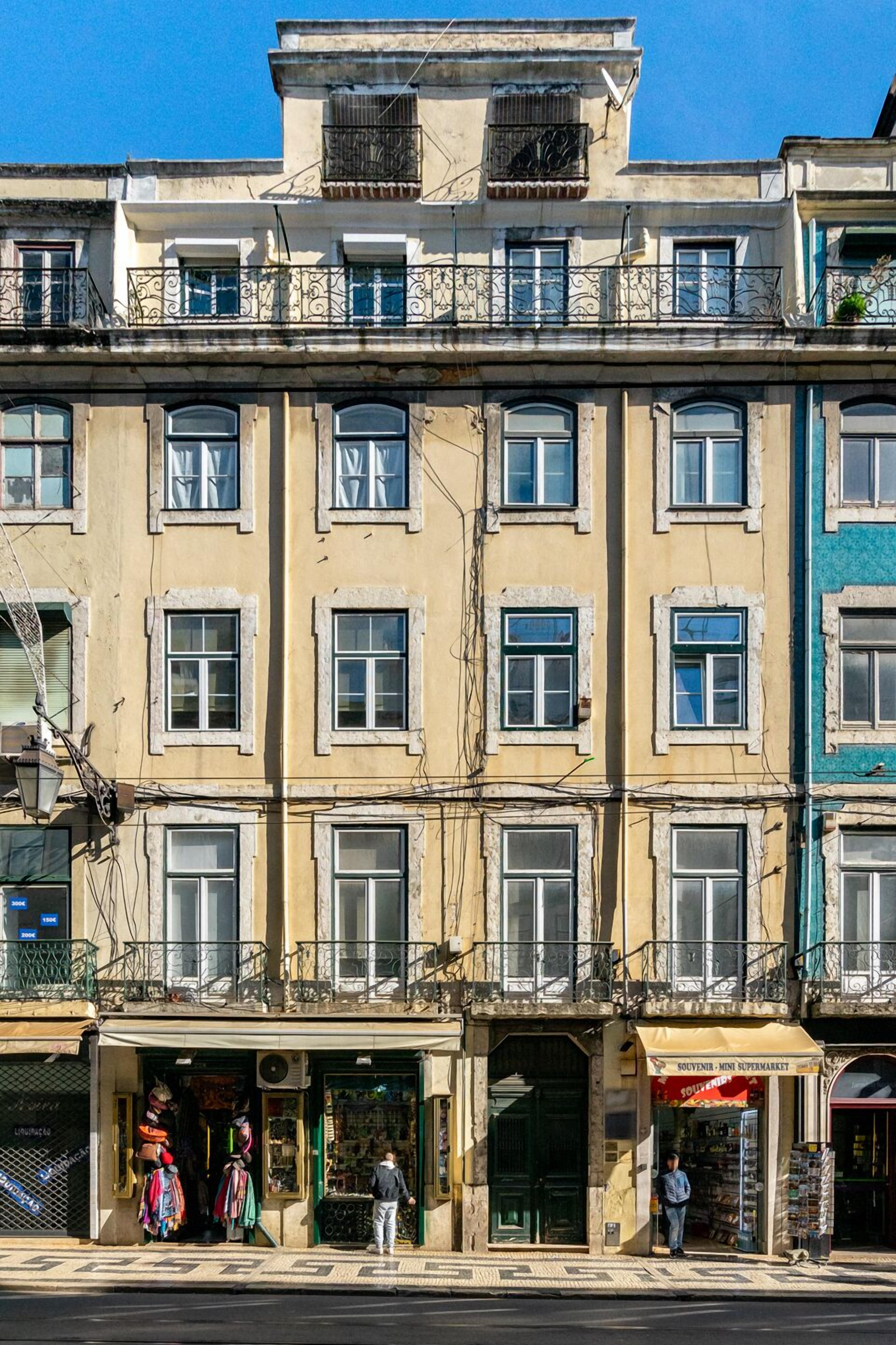 A multi-story building with a ground-level shop and a visible balcony.