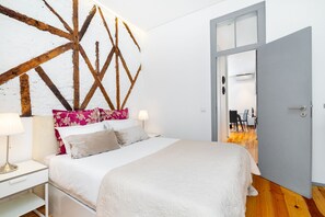 Une chambre à coucher comprenant un lit, des tables de chevet, une lampe et un mur décoratif en bois.