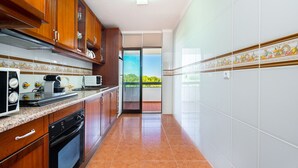 A kitchen with wooden cabinets, a microwave, a coffee maker, and a dishwasher.