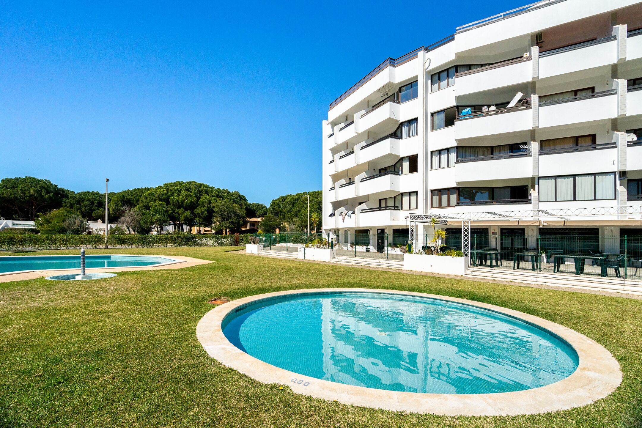 A modern building with multiple balconies and a pool area.