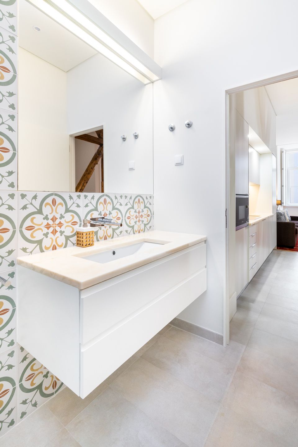 A modern bathroom with a large mirror, a sink, and a toilet.