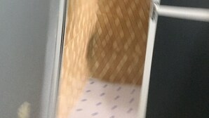 Una habitación con piso estampado, una cama con colcha estampada y una puerta con picaporte.