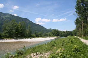Escape to a serene riverside haven surrounded by lush greenery and majestic mountains.