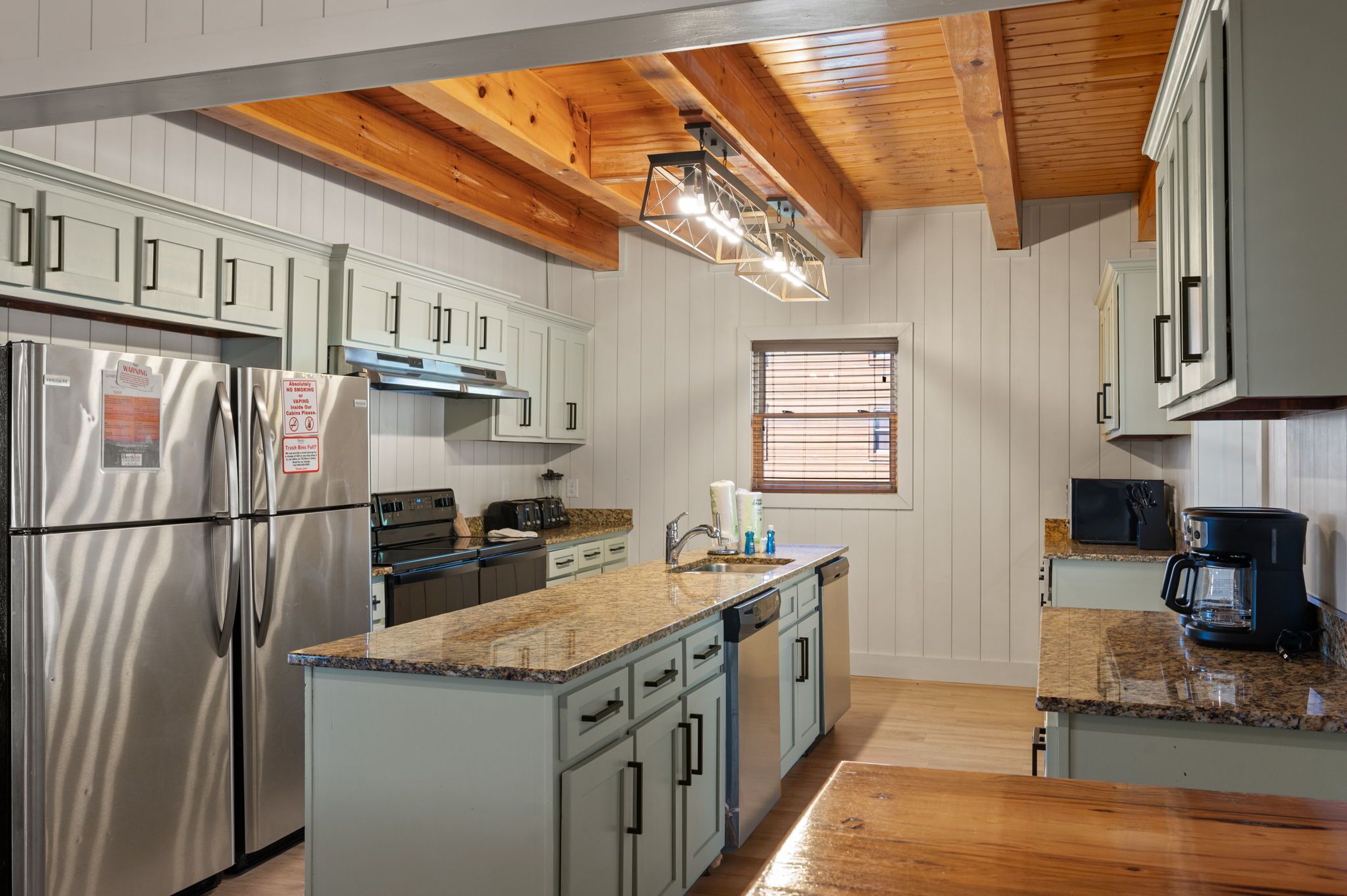 A kitchen with white cabinets, stainless steel appliances, and a granite countertop.