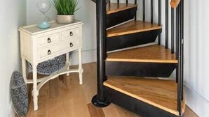 A spiral staircase with black railings and wooden steps, leading to an upper floor. - Luxury Private Suite with HEATED SALTWATER POOL (65120 Viella,)