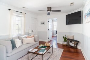 A living room with a sofa, coffee table, and a television.
