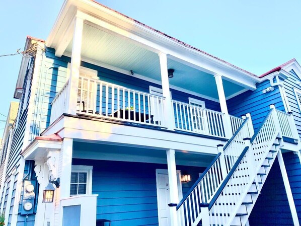 A two-story building with a balcony and a staircase.
