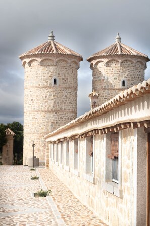 A stone building with two towers and a covered walkway.