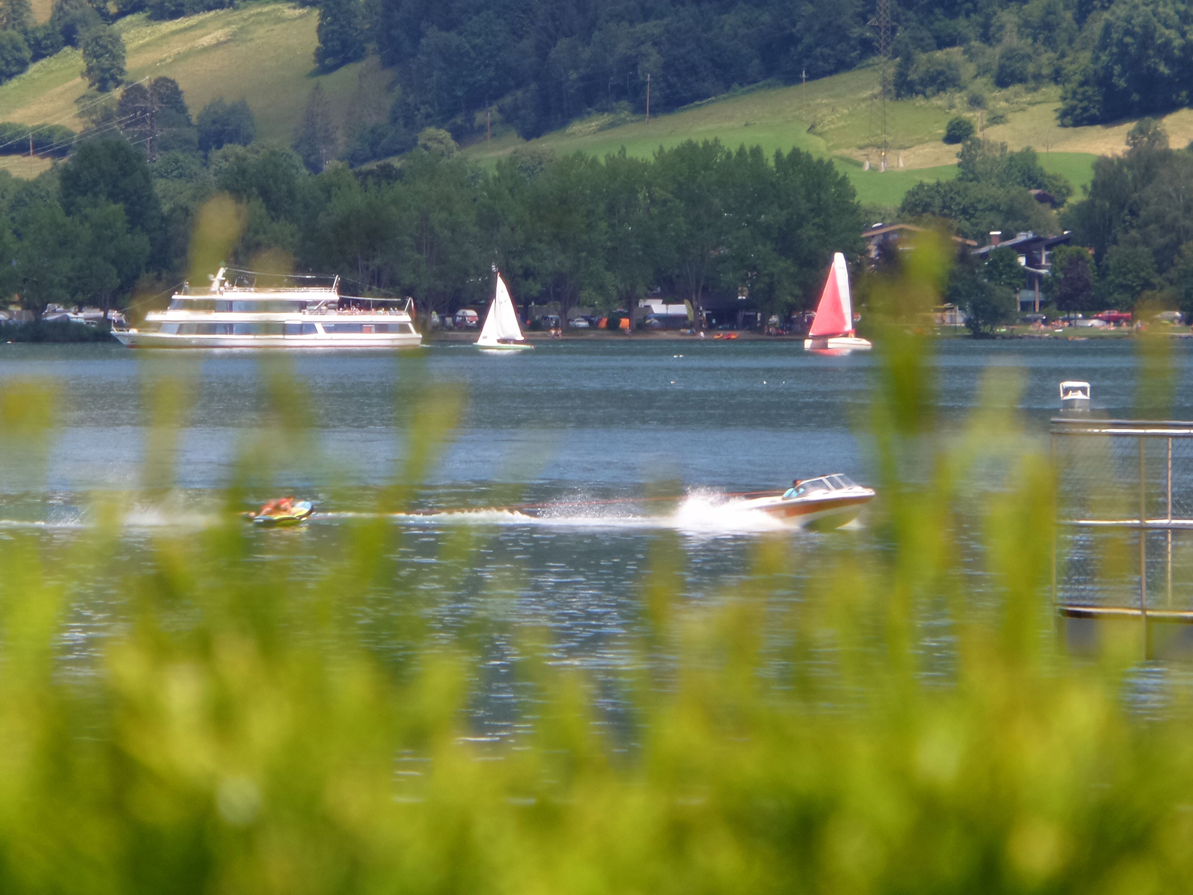 A lake with boats and a sailboat.
