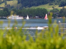 Un lago con barcos y un velero.