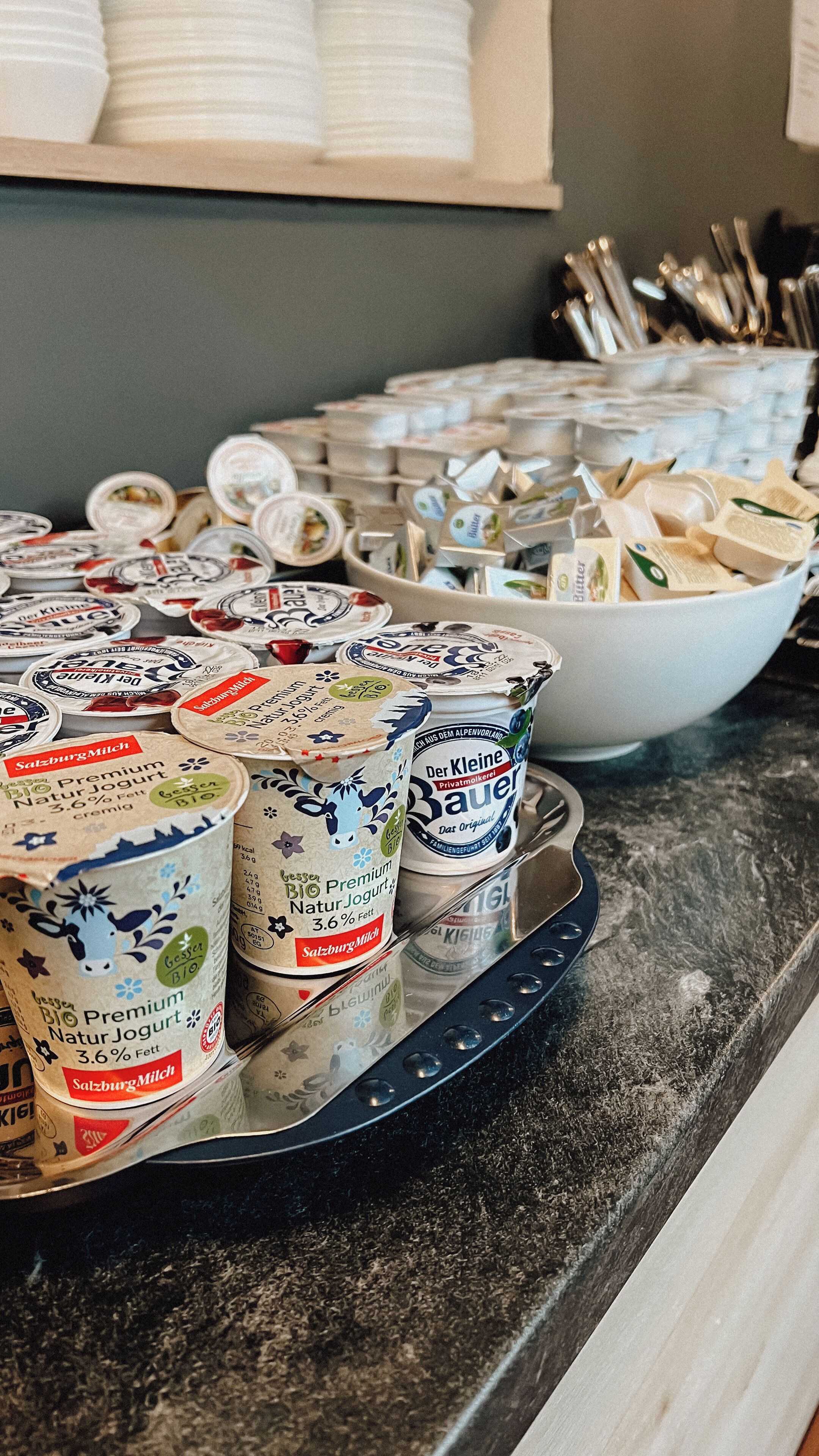 A buffet table with various dairy products, including yogurt and cheese.