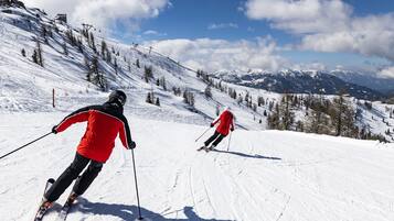 Une piste de ski enneigée où l’on voit des skieurs en mouvement.
