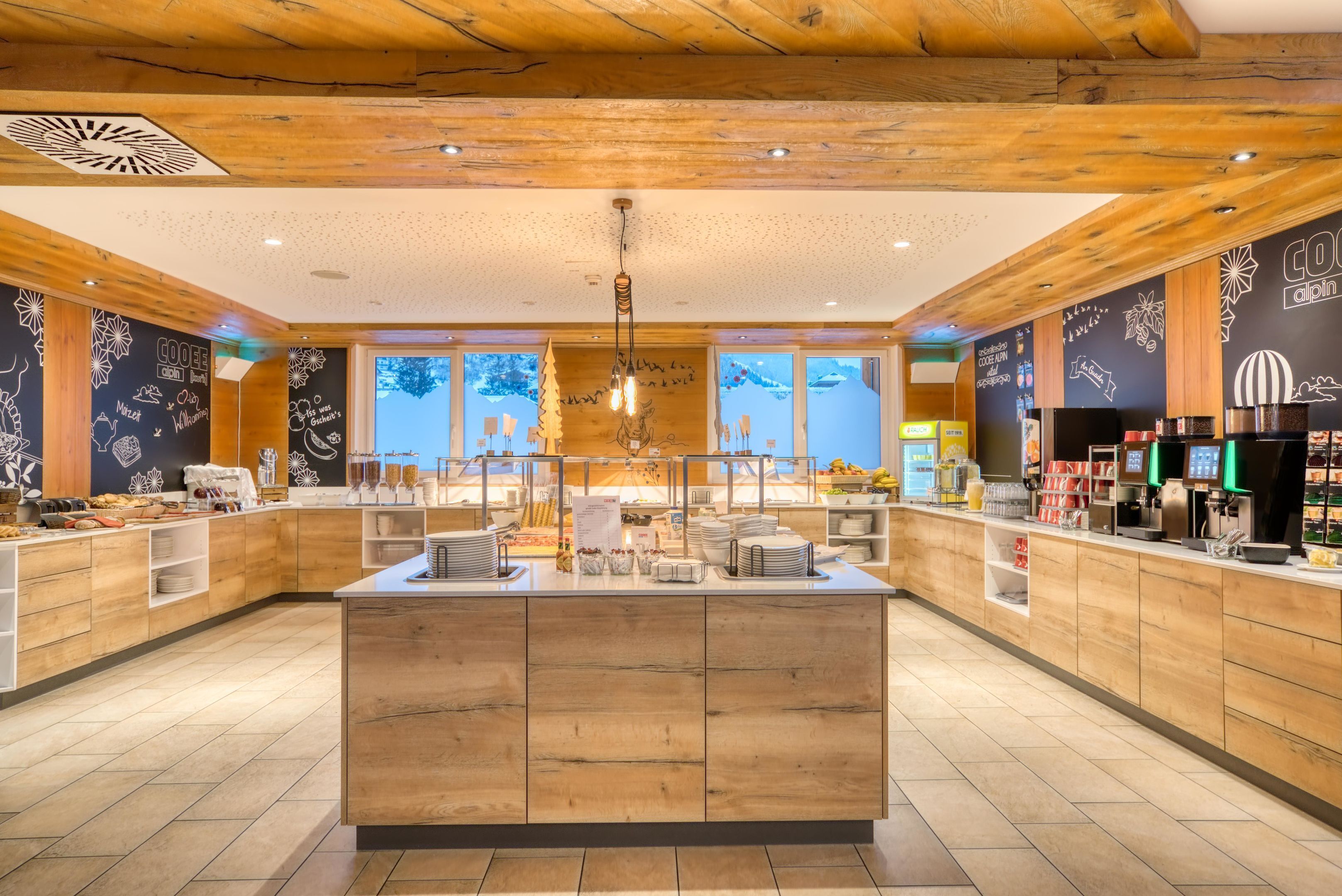 A modern kitchen area with wooden cabinets, a central island, and a coffee station.
