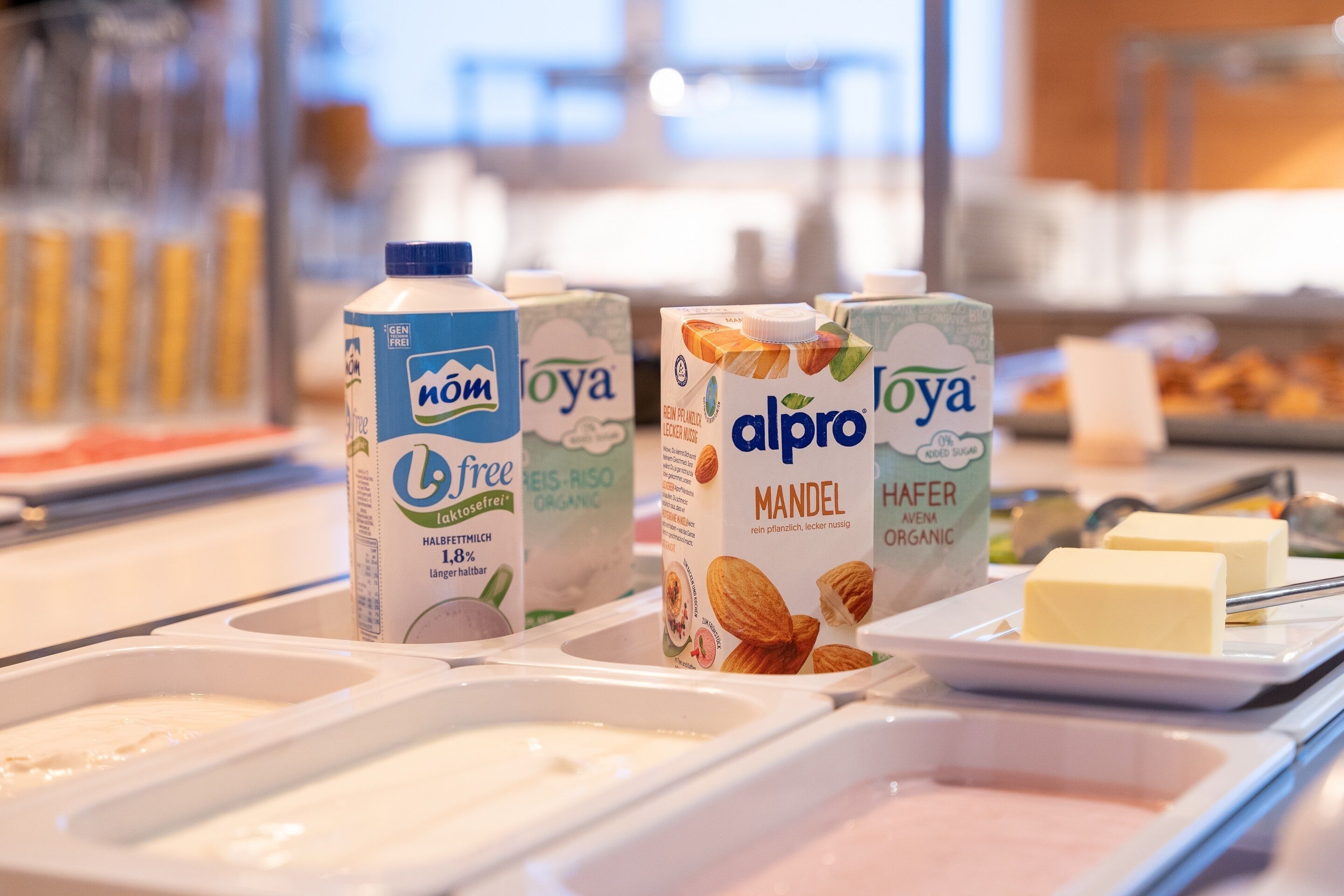 Un buffet de petit-déjeuner avec différents types de lait en brique et du beurre.