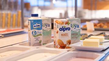 A breakfast buffet with various milk cartons and butter.