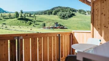 Ein Balkon mit Blick auf eine grüne Landschaft und ein Gebäude in der Ferne.