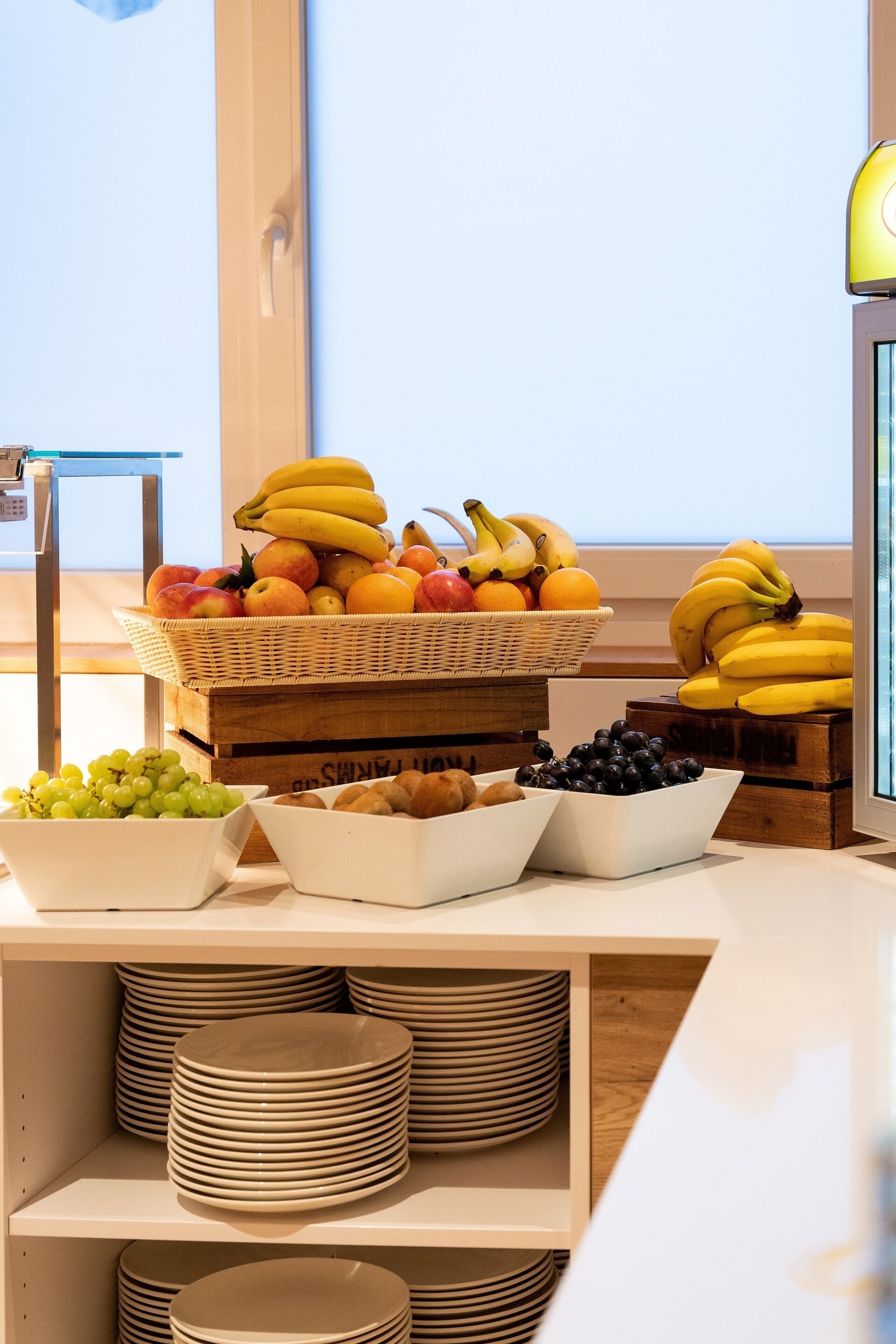 Een buffettafel met verschillende soorten fruit en schalen vol druiven en bosbessen.