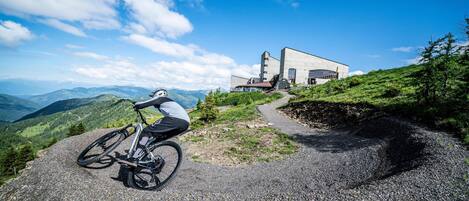 A mountain bike on a gravel path with a modern building in the background.