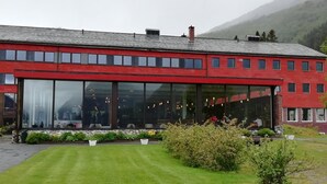 Un edificio rojo con grandes ventanales y base de piedra.