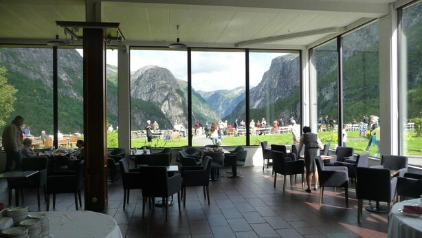 Un restaurante con amplios ventanales que ofrece vistas a un paisaje montañoso.