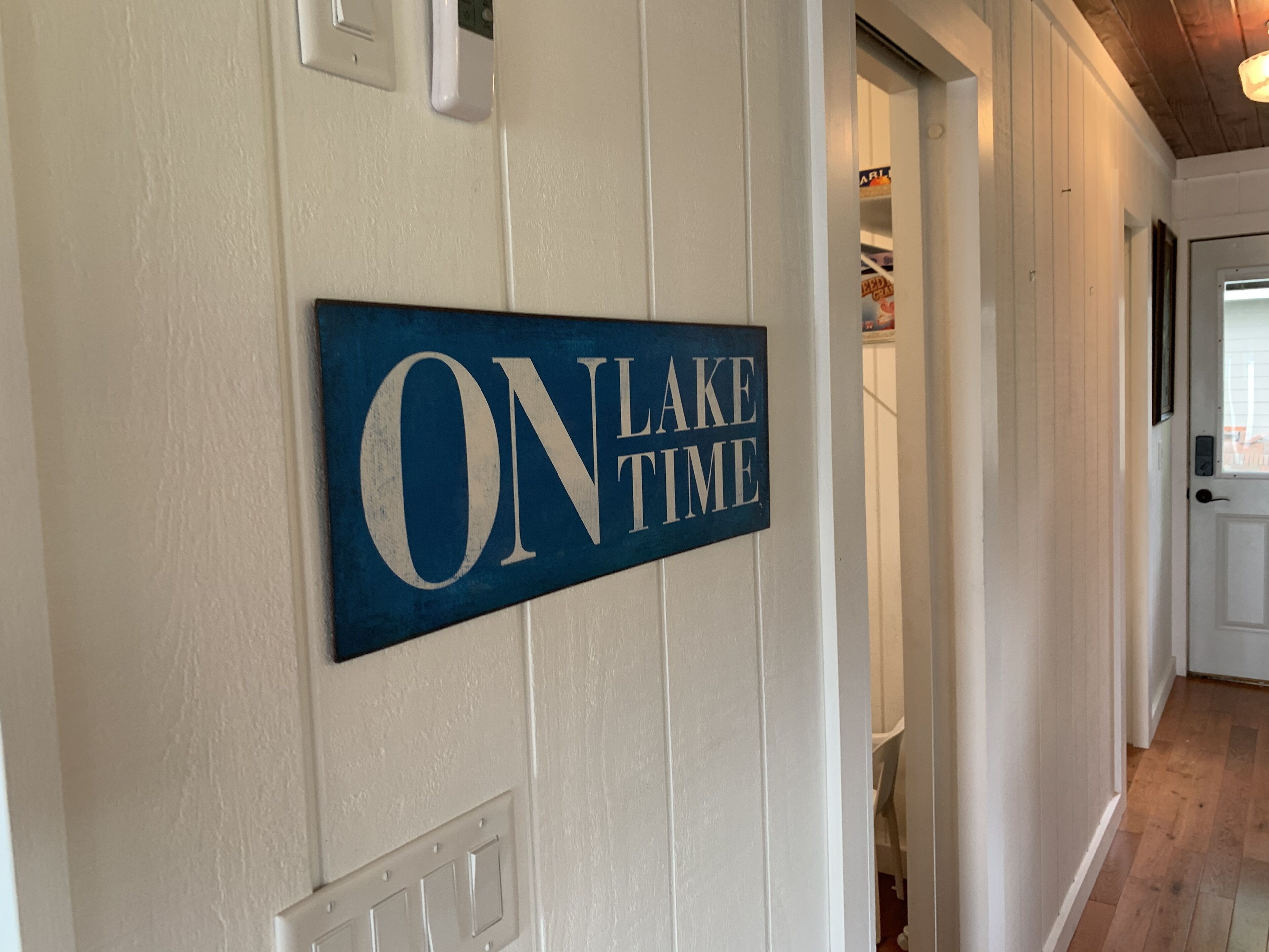 A hallway with a sign reading "ON LAKE TIME" on the wall.