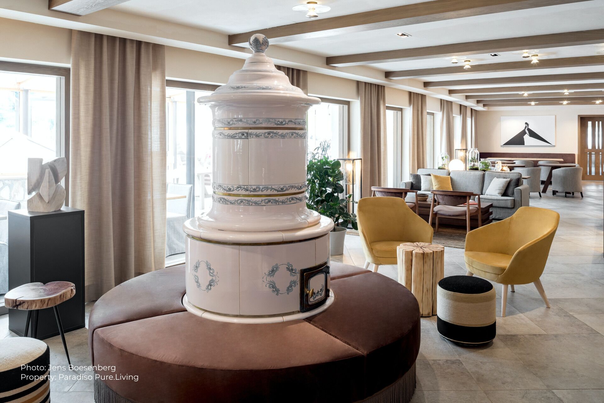 Een moderne woonkamer met een grote decoratieve vaas, comfortabele zithoek en uitzicht op de omgeving.
