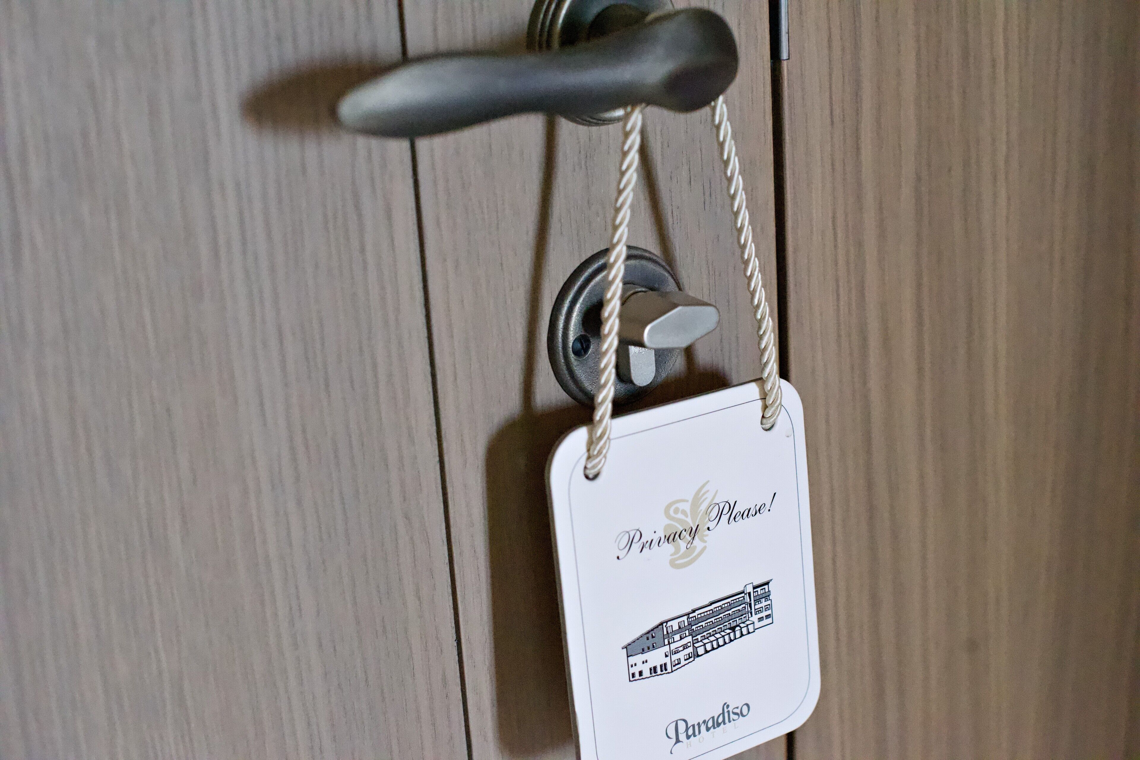 Une poignée de porte et une étiquette indiquant «Ne pas déranger! Paradiso».
