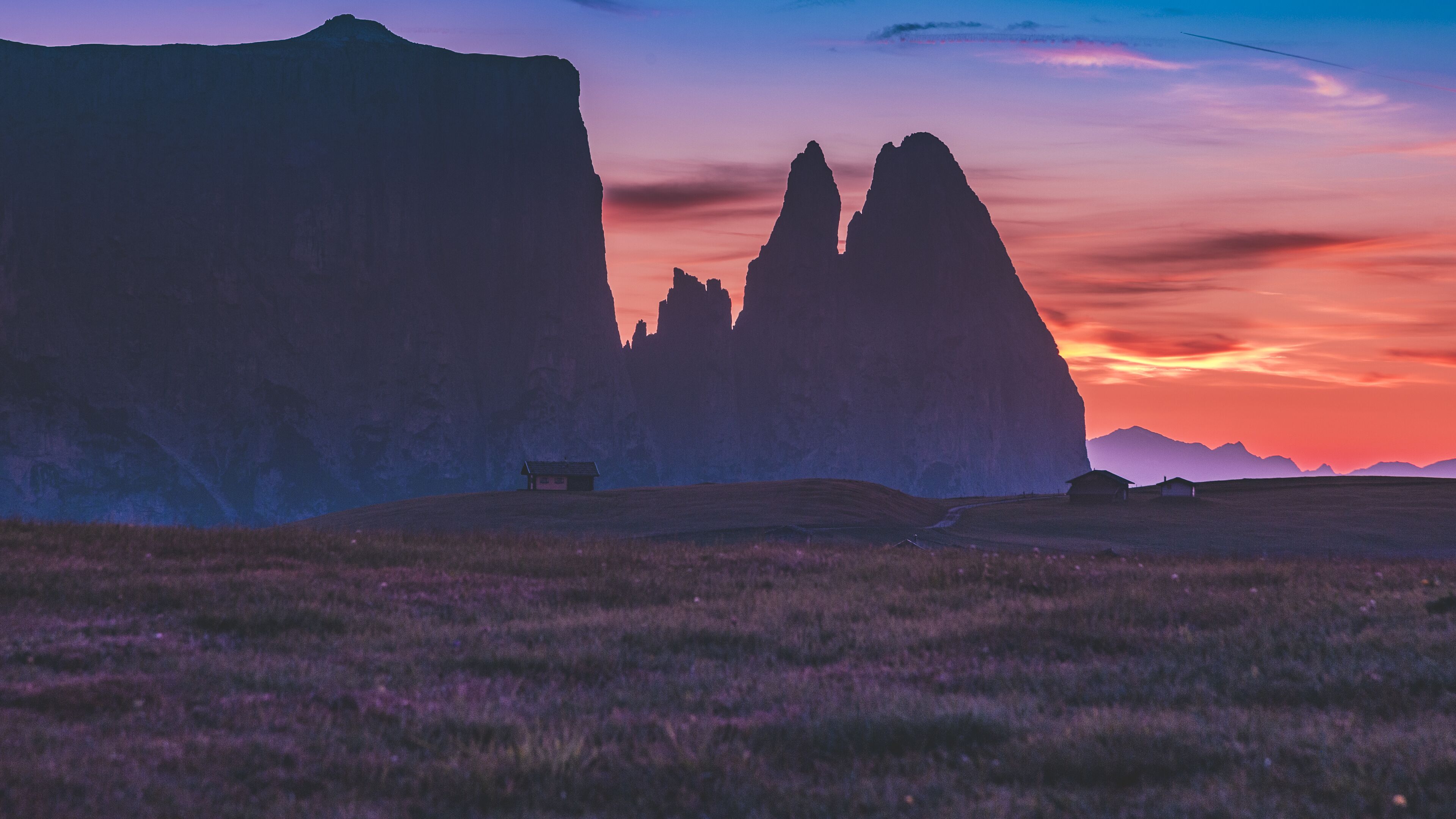 A landscape with rock formations and a small building.