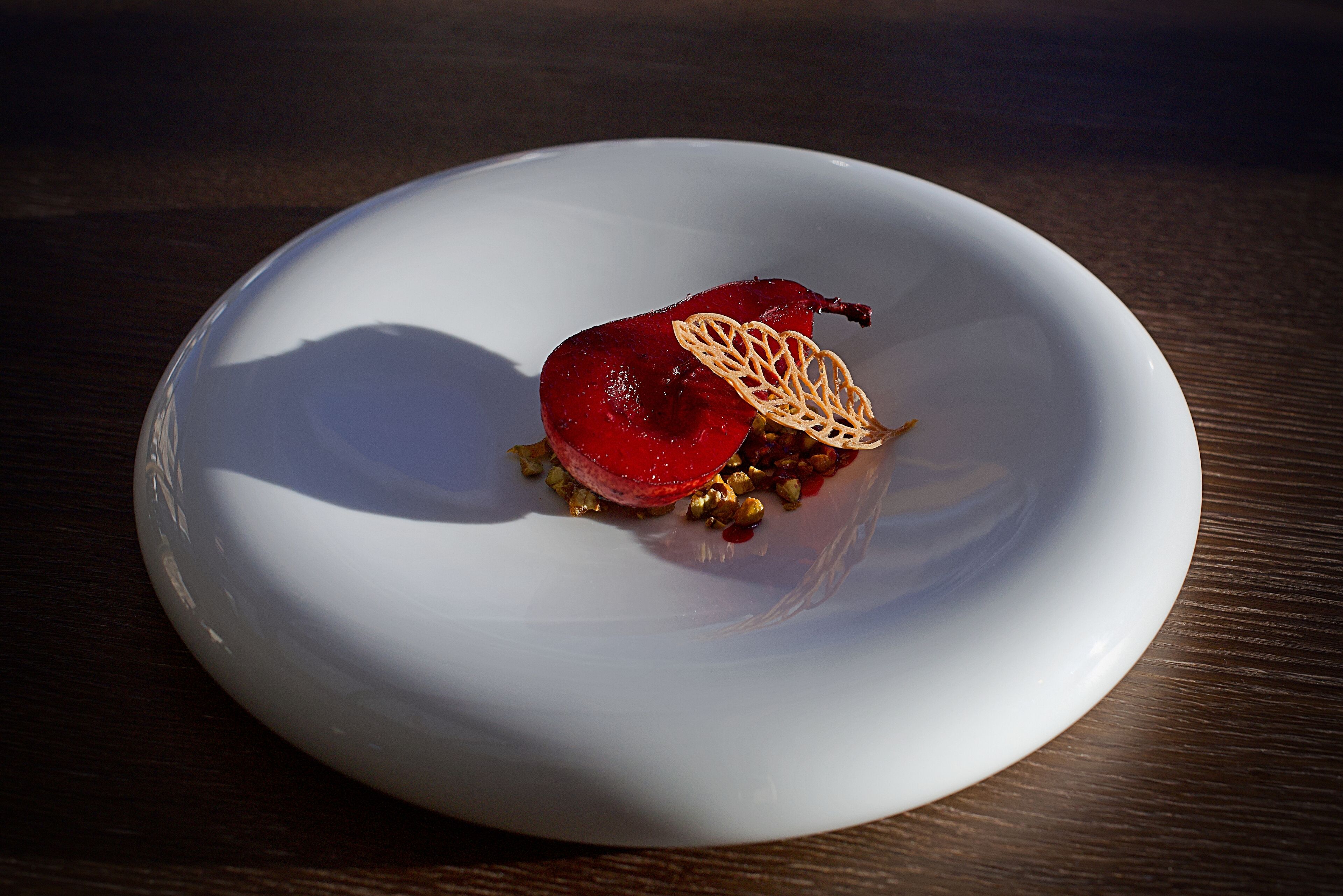 A white plate with a dessert on a wooden table.