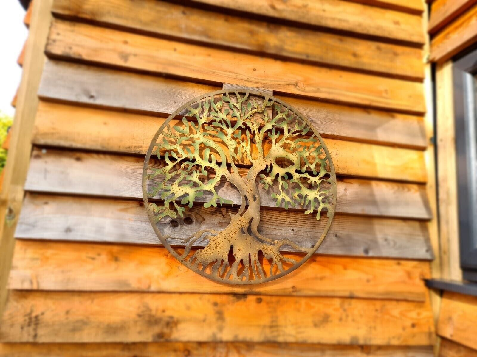 En rund metaltraeskulptur monteret på en trævæg.