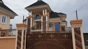 Il s’agit d’une propriété résidentielle fermée, dotée d’une porte d’entrée imposante, d’un balcon et d’un style architectural distinctif.