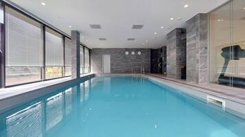 Una piscina coperta con vista diretta sull'area della piscina, ampie finestre e un design d'interni moderno.