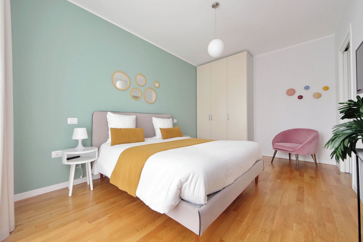A modern bedroom with a bed, bedside tables, a wardrobe, and a chair.
