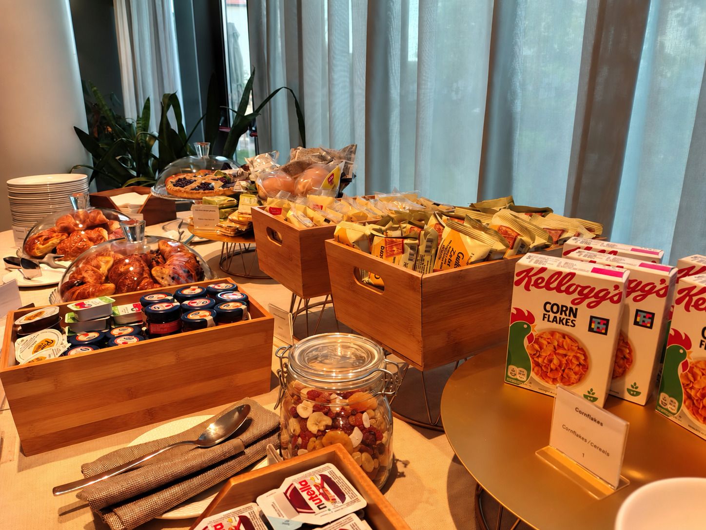 Una mesa de buffet con diversos alimentos, como pasteles, quesos y cereales.