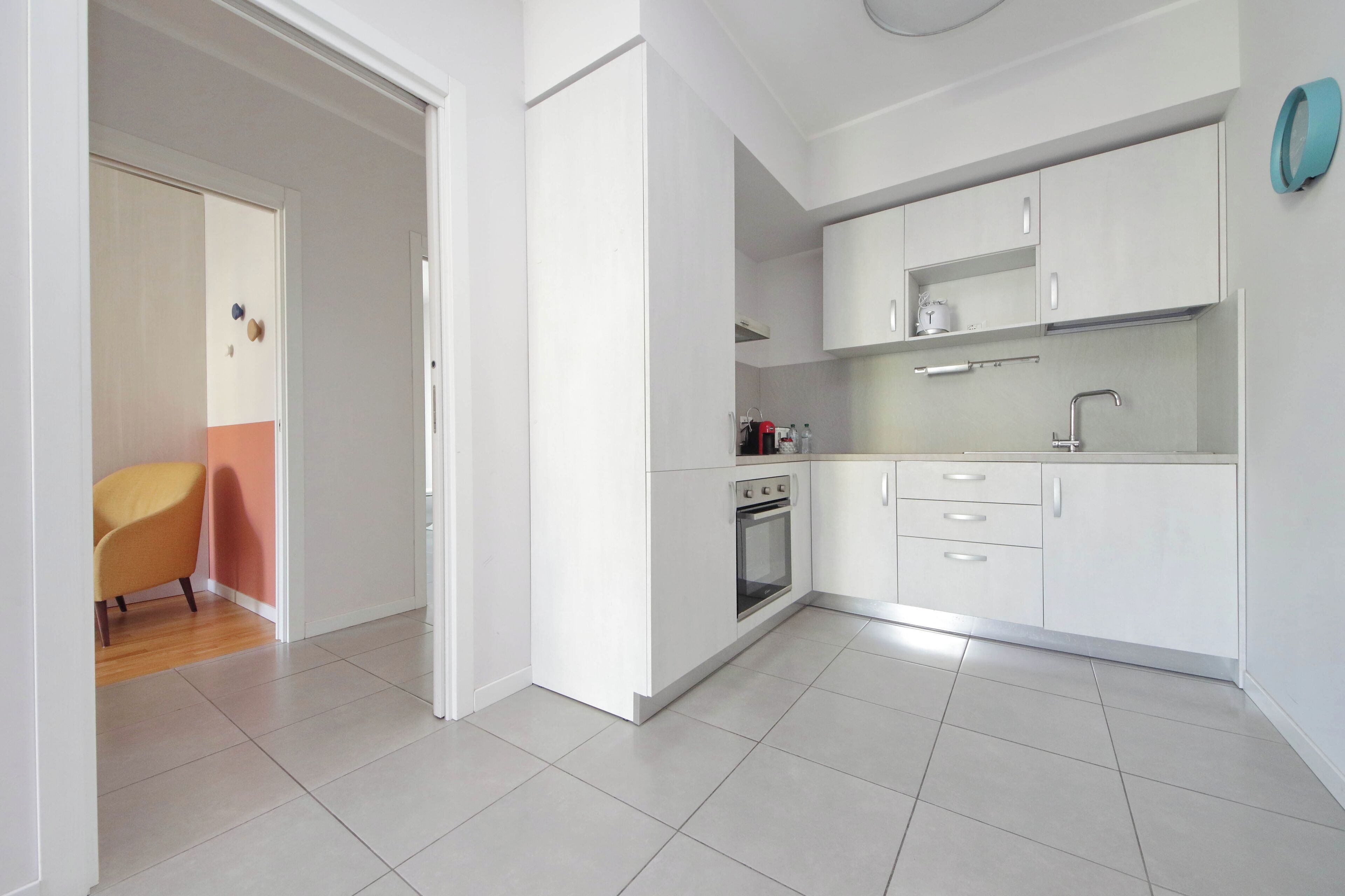 A modern kitchen with white cabinets, a built-in oven, and a countertop.