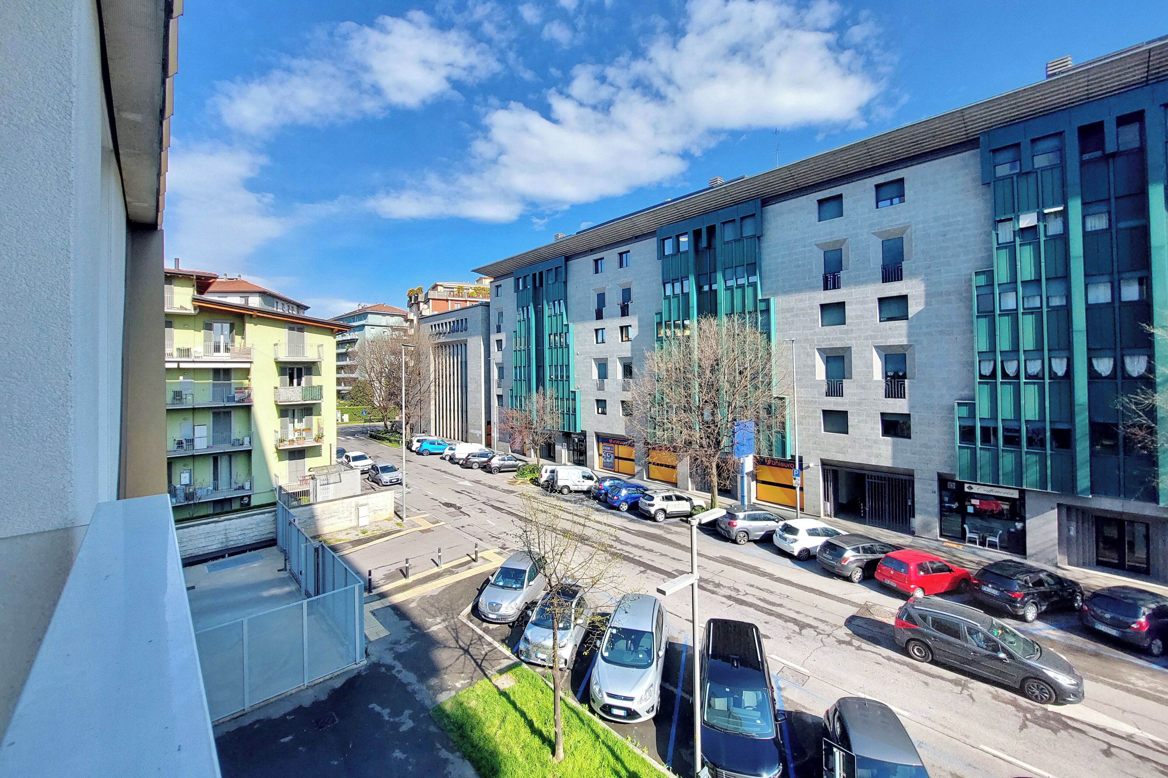 A multi-story building with a parking lot in front.