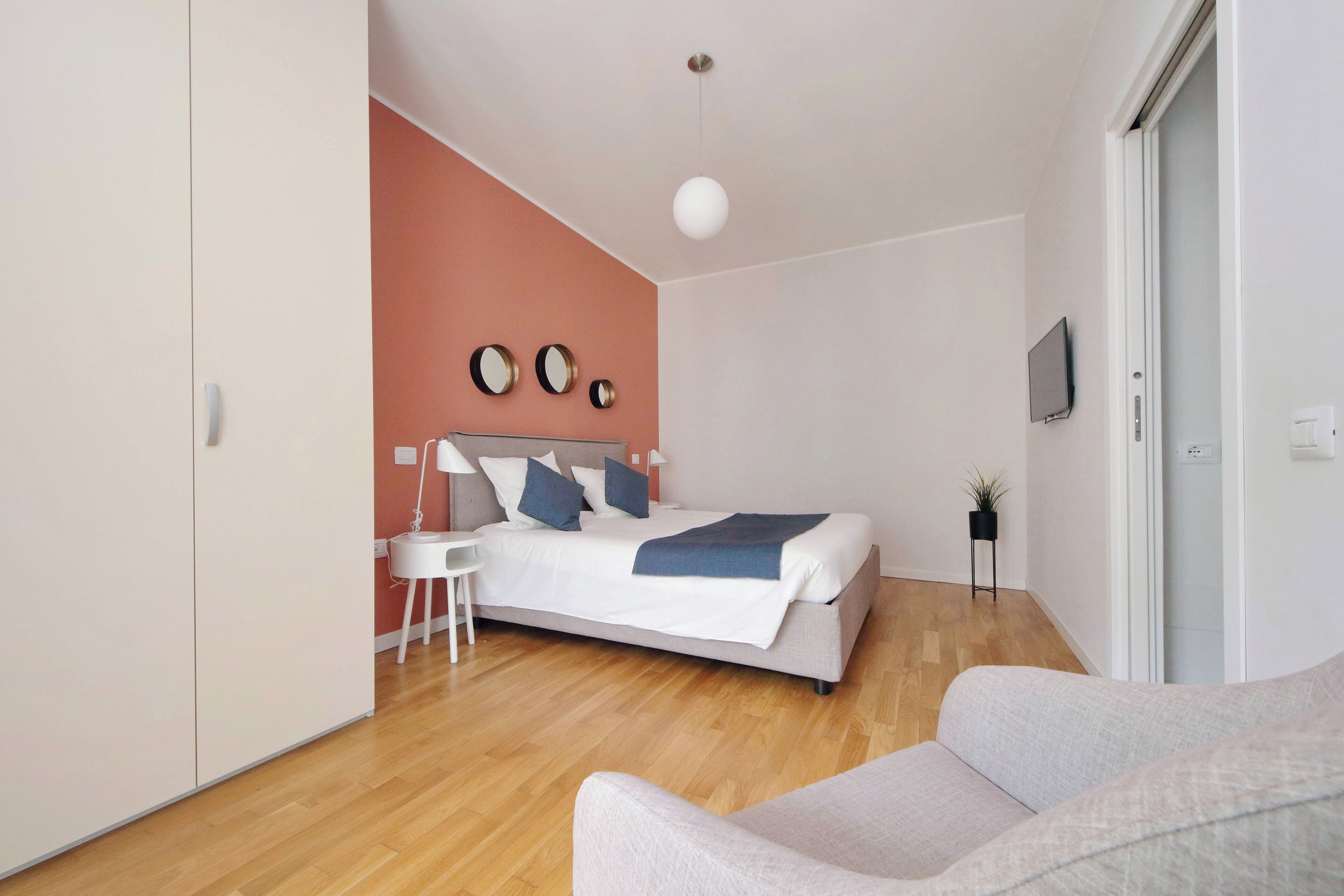 A modern bedroom with a bed, bedside table, and a TV.